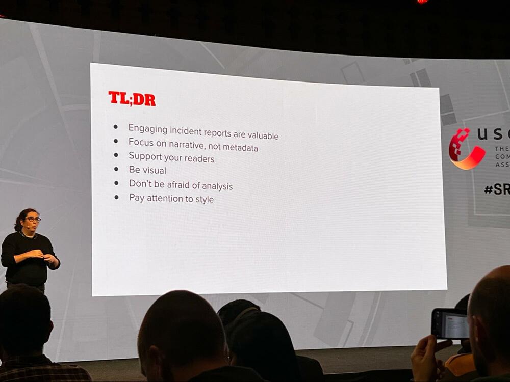 An image of Laura on stage with a slide saying the TL;DR of the talk